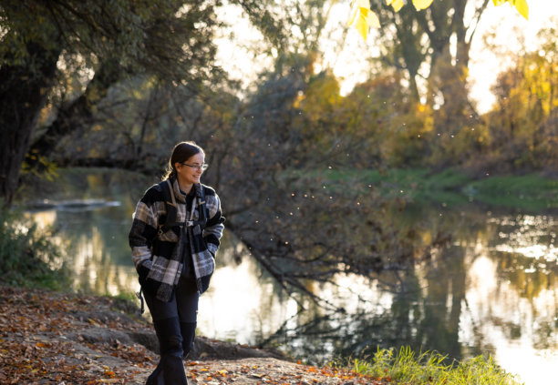 傍晚时分，女子在风景如画的湖边探索大自然——素材照片图片下载