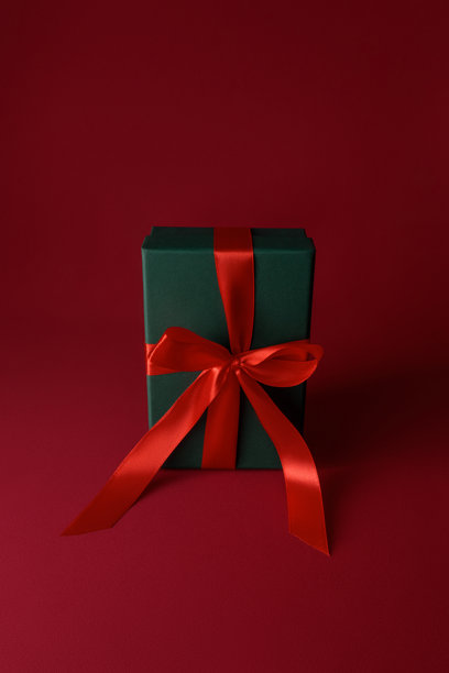 新年和圣诞节主题图片，明信片模型，一个打开的绿色礼品盒，里面装着红色纸屑，背景为红色天鹅绒窗帘，礼品包装图片下载