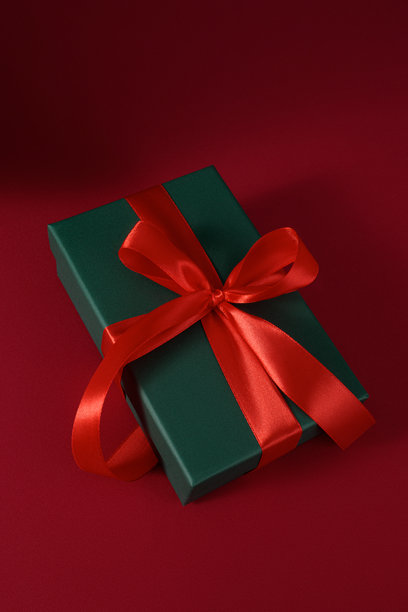新年和圣诞节主题图片，明信片样机，打开的绿色礼品盒，里面有红色彩带，背景为红色天鹅绒窗帘，礼品包装图片下载