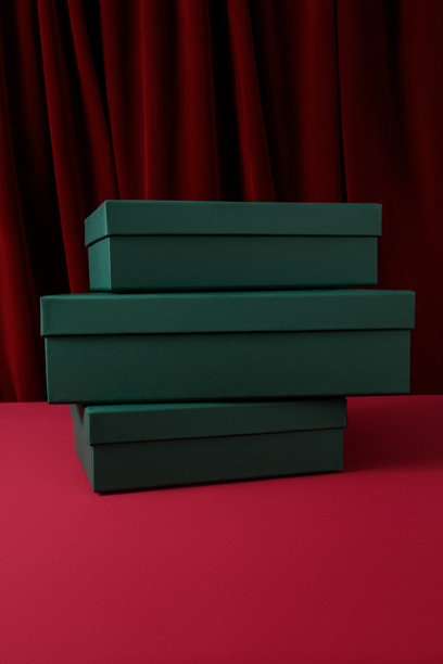 新年和圣诞节主题的图片，明信片样机，打开的绿色礼品盒，里面有红色纸屑，背景为红色天鹅绒窗帘，礼品包装图片下载