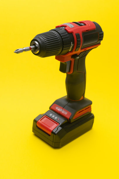 垂直照片 专业无线螺丝刀，孤立在充满活力的黄色背景上。图片下载
