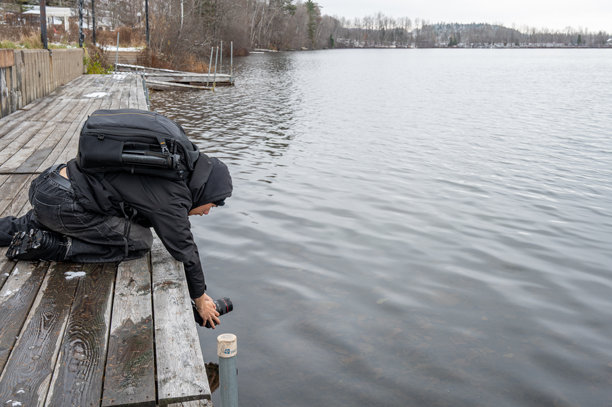 年轻男子正在拍摄湖泊的照片图片下载
