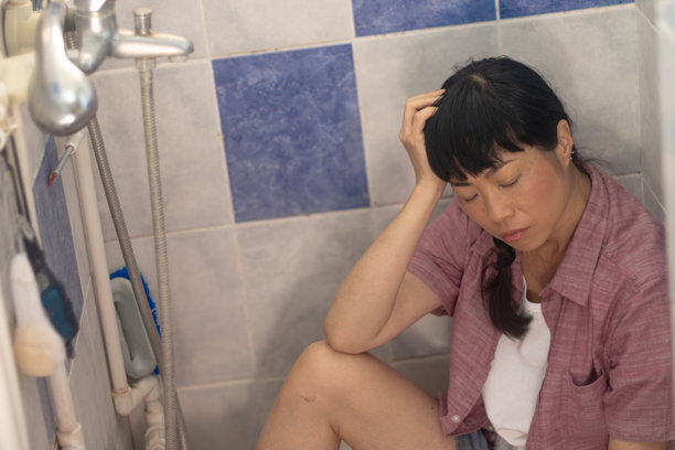 Woman having mental health crisis sitting in shower图片下载