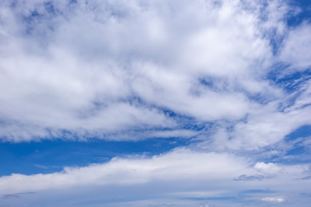 蓝天白云全景，带有细小云朵的蓝天背景。蓝天中的白色蓬松云朵。引人入胜的图库照片，展现天空和云朵的迷人美景。图片下载