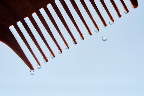 一把带有护发精华的梳子。照片展示了化妆品的质地。图片下载