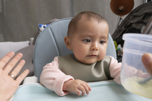 妈妈在高脚椅上喂宝宝吃辅食图片下载