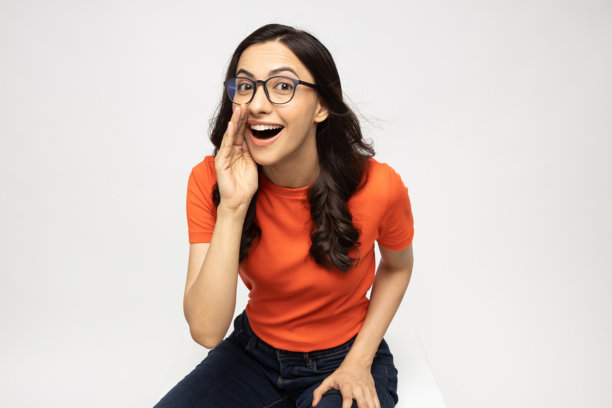 身穿橙色T恤的漂亮年轻女子，白色背景隔离的素材照片图片下载