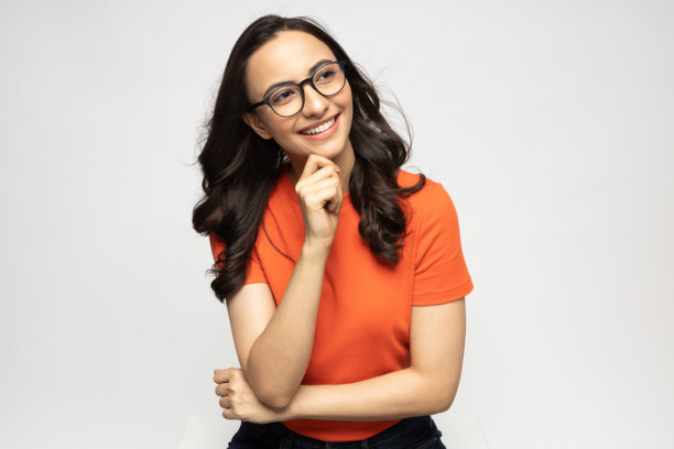 穿着橙色T恤的漂亮年轻女子，在白色背景下拍摄的素材照片图片下载