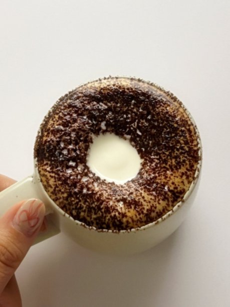 一杯精心制作的拿铁，浓郁的意式浓缩咖啡上覆盖着绵密的奶泡拉花。这张图片完美捕捉了经典咖啡馆体验的温暖与诱人之处，非常适合咖啡相关项目。图片下载