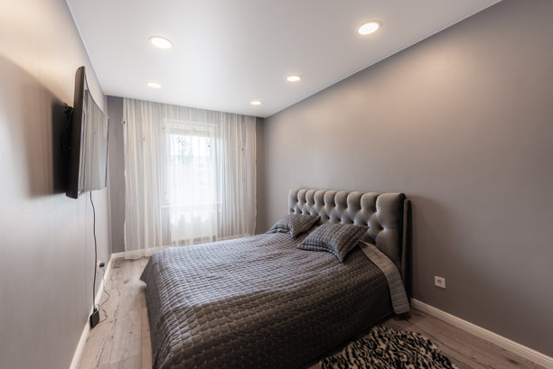 现代家居卧室，配有灰色装饰、平板电视和优雅的软包床图片下载