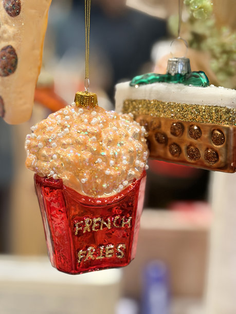 一张有趣的圣诞树图片，上面装饰着薯条形状的装饰品、俏皮的彩球和节日装饰。图片下载