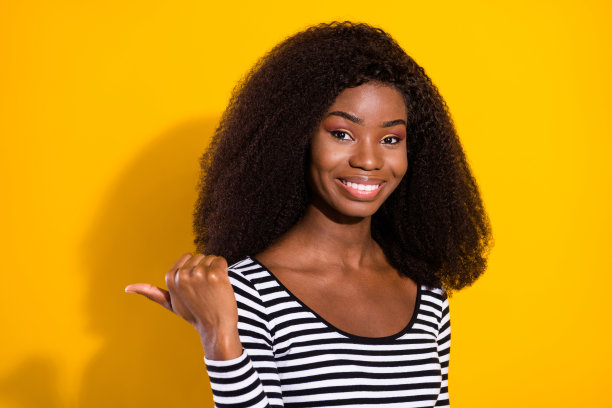 年轻模特展示空白空间的照片肖像，带着微笑，孤立在充满活力的黄色背景上图片下载