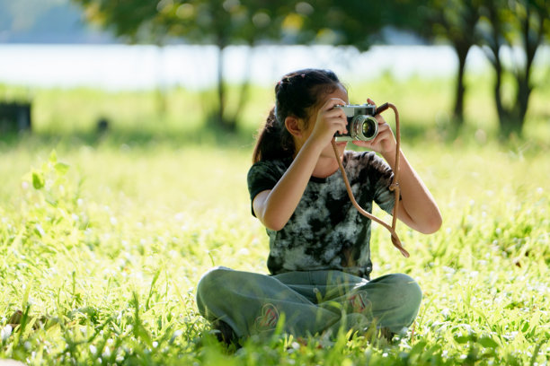 女孩用数码相机拍摄自然研究照片图片下载