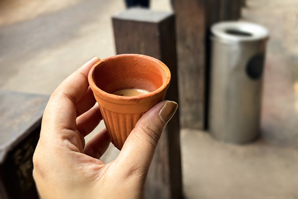 手持印度拉茶（Chai）的Kulhad杯的特写视角。街边用Kulhad杯饮用奶茶。图片下载