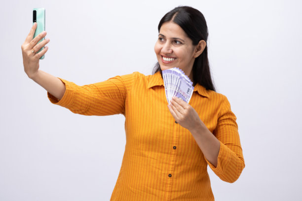 身穿黄色库尔塔、展示印度卢比的成年女性照片，孤立在白色背景上图片下载