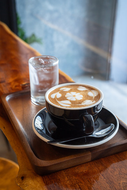 咖啡店里的热拿铁咖啡，杯子上有拉花奶泡，搭配自制比利时华夫饼和蜂蜜，摆放在木桌上，俯视角度，适合作为咖啡店或咖啡馆的商务工作早餐。图片下载