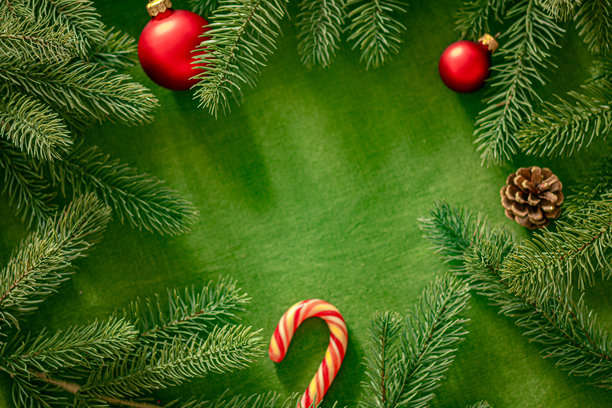 绿色背景上的圣诞节装饰画框，配有拐杖糖和松果图片下载