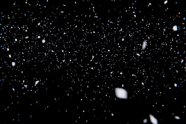 飘落的雪景叠加素材。白色粒子和模糊散景的抽象纹理，背景为纯净的黑色。非常适合用于冬季、节日或氛围感照片的合成。图片下载