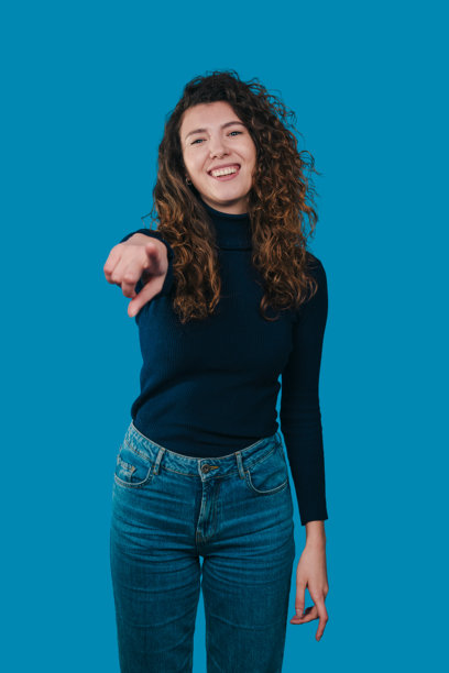 明亮自信的宣传图片，一位穿着海军蓝毛衣和牛仔裤的年轻女子自信地微笑图片下载