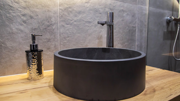 悬挂式木制橱柜中的时尚现代灰色石材浴室水槽和镀铬水龙头。墙壁上有灰色瓷砖，室内设计。图片下载