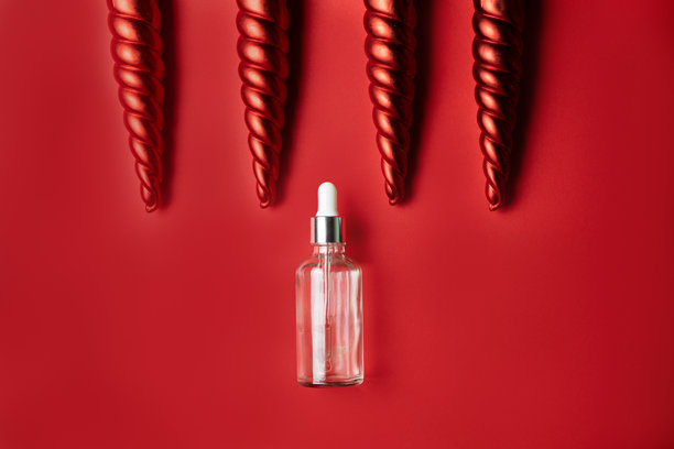 红色背景上的化妆品精华液，配有红色的冰柱形装饰图片下载