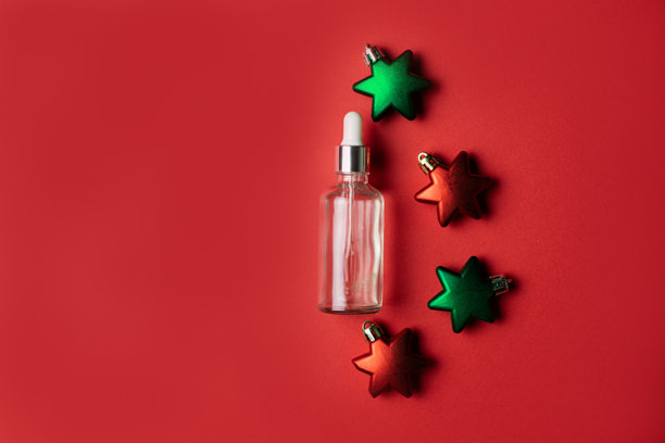红色背景上的星形圣诞装饰品化妆品精华液，留有复制空间图片下载