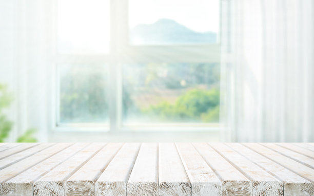 背景虚化的大窗户玻璃墙和抽象山景，上面是漂亮的白色复古木桌桌面图片下载