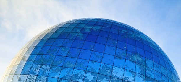 图片展示了由蓝色镜面玻璃制成的圆顶立面碎片，反射着天空和云彩。图片下载