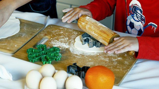 一个孩子正在使用擀面杖和饼干模具准备圣诞饼干图片下载