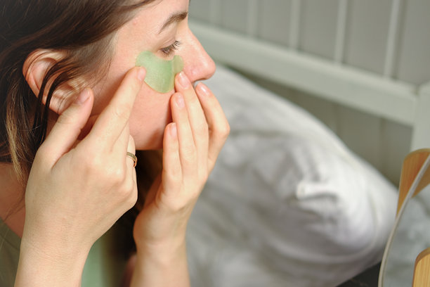 一位40多岁的女性正在早晨进行面部自我护理，她正用滴管将精华液涂抹在脸上。护肤品。女性用油性滴管涂抹精油。化妆品广告。健康。图片下载