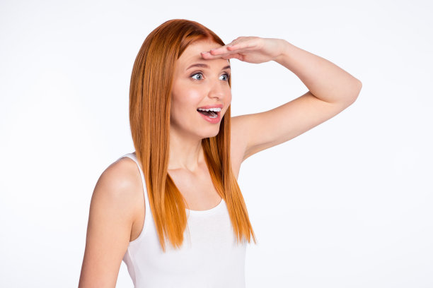 年轻女孩侧面照片，兴奋、快乐、积极的微笑，向前看，促销，孤立在灰色背景上图片下载