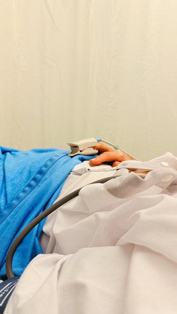 患者在临床检查和医疗护理过程中，手连接着医疗监测设备，在医院病床上休息的专业照片图片下载