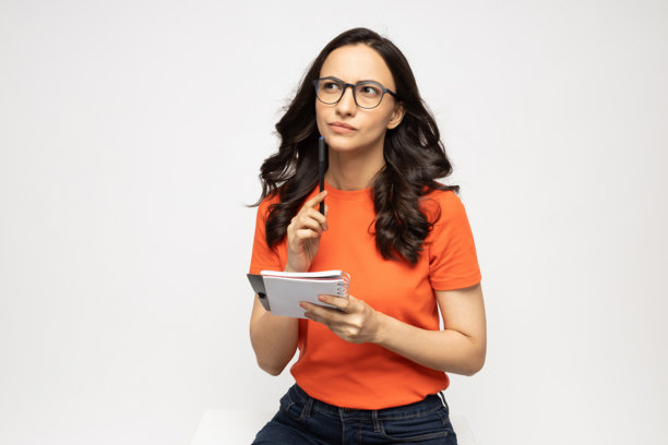 身穿橙色T恤的漂亮年轻女性，白色背景下的照片素材图片下载