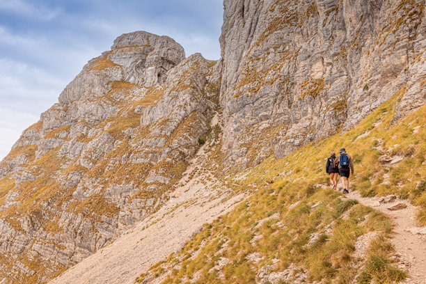 人们背着背包徒步登山，在崎岖的山路上向上攀登图片下载