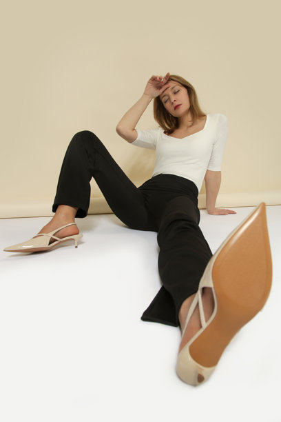 年轻女模特身穿简约漂亮的服装，白色棉质衬衫和黑色长裤的系列工作室照片图片下载