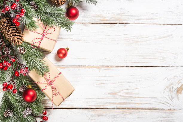 白桌上的冬青圣诞树，覆盖着雪，并饰有装饰品。图片下载