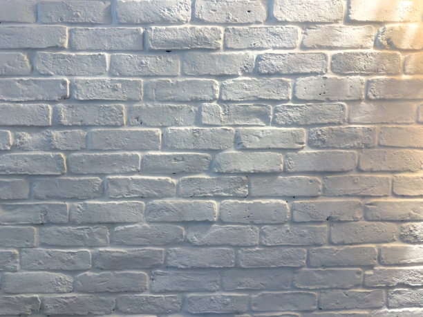 柔和的午后光线下的白色砖墙，具有纹理表面和微妙的阴影图片下载
