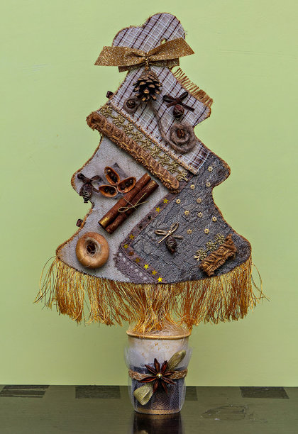 手工制作的圣诞树，由织物、珠子和其他装饰物组成图片下载