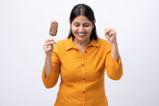 一位中年女性在白色背景上吃冰淇淋的图片素材图片下载