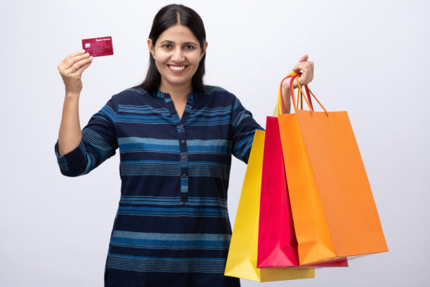 身穿蓝色库尔塔、手提购物袋的中年女性在白色背景上的照片素材图片下载