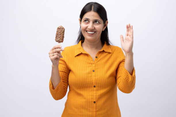 一名中年女性在白色背景上吃冰淇淋的特写照片图片下载