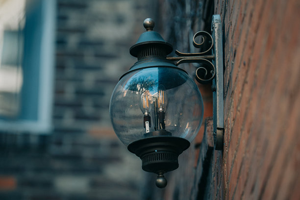 砖墙外立面上的复古玻璃灯笼，映照着都市景象图片下载