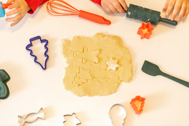 孩子们在温馨的厨房里，使用色彩鲜艳的饼干模具和工具烘焙节日饼干图片下载