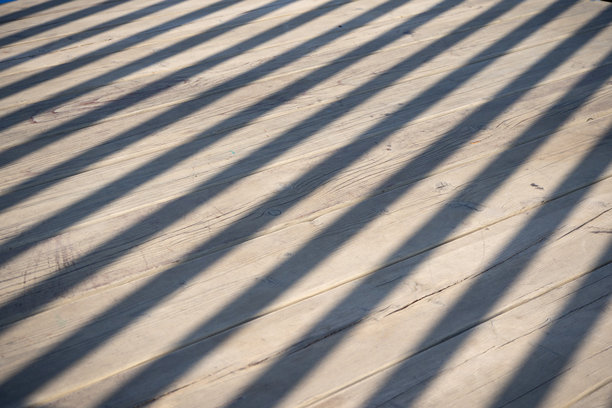 木质背景，带有阴影。木质甲板，带有倾斜的阴影条纹，来自百叶结构。适用于建筑、户外设计或抽象背景的纹理。真实照片图片下载