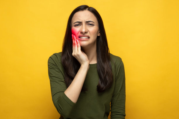 身穿橙色T恤的漂亮年轻女子，背景为黄色，照片素材图片下载