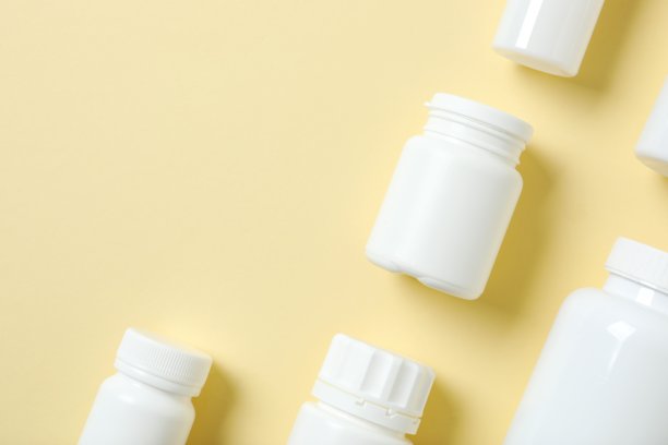 白色塑料药丸或维生素膳食补充剂瓶，医疗药物塑料瓶，米色背景，包含剪贴路径。高分辨率照片。俯视。图片下载