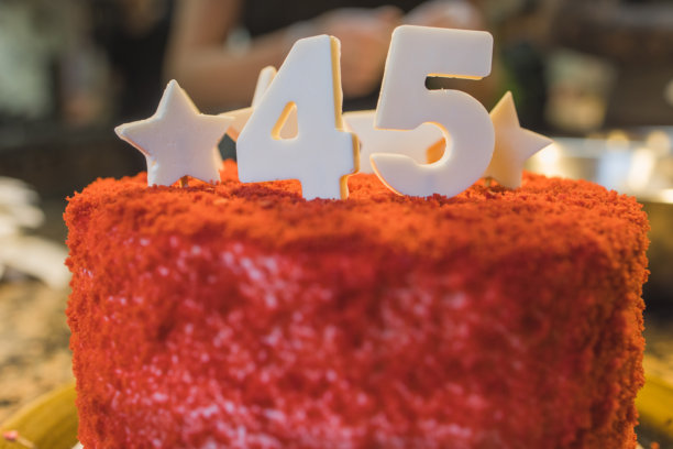 生日蛋糕上有蜡烛。蛋糕上的蜡烛。节日蛋糕。漂亮的白色蛋糕配草莓，背景为深色。竖幅照片。图片下载