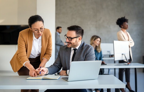 在办公室的商务男士与同事交易员在屏幕上监控股票数据，分析价格走势图片下载