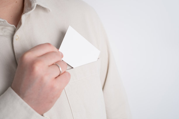 手从衬衫口袋里拿出一张空白白卡，用于个人品牌推广。名片模型概念。图片下载