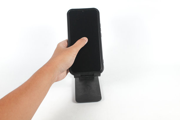 一只手正在触摸固定在支架上的已损坏手机的屏幕图片下载